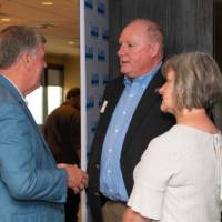 2 attendees talk with tom haas